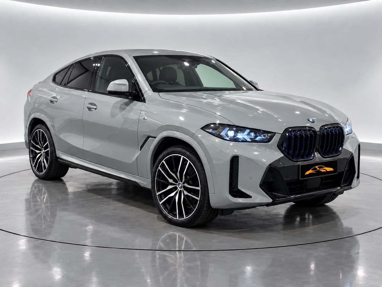 BMW X6 xDrive30d M Sport in light grey, front three-quarter view with illuminated kidney grille