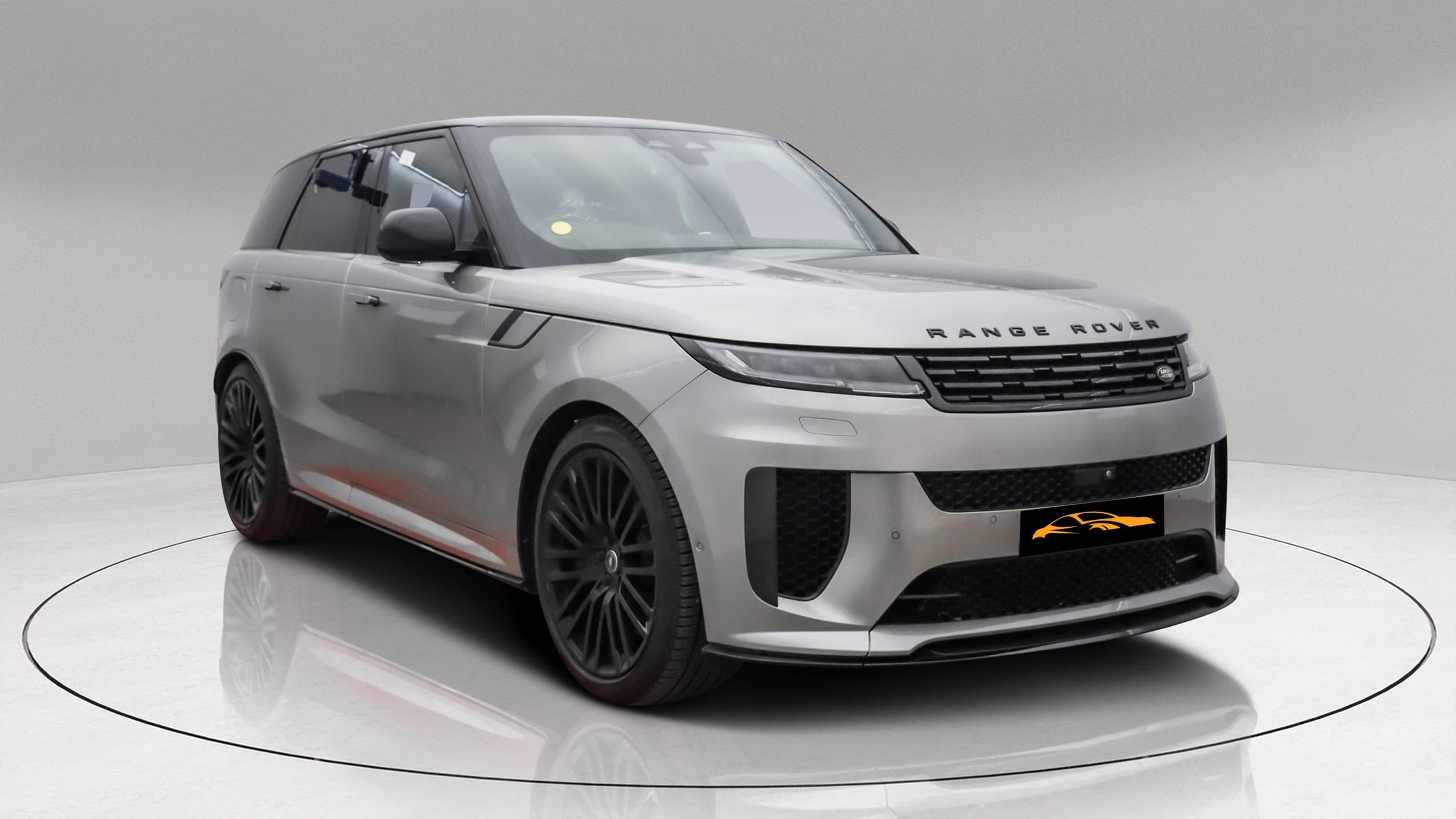 Range Rover Sport SV P635 in satin silver with black roof, front three-quarter view showing the SV bumper and gloss black alloy wheels